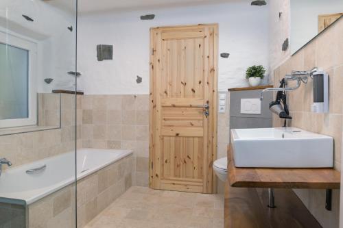 a bathroom with a sink and a tub and a toilet at Gemütliches Ferienhaus in Kell am Traumpfad nahe Maria Laach in Andernach