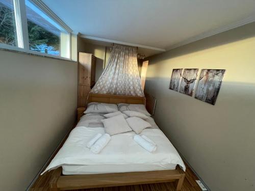 a small bedroom with a bed with white sheets and pillows at ALPENLOFT vom Berg zum See inklusive gratis KärntenCard in Kanzelhöhe