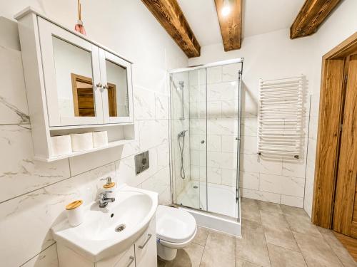 a white bathroom with a sink and a shower at Farma Puchałowo in Puchałowo
