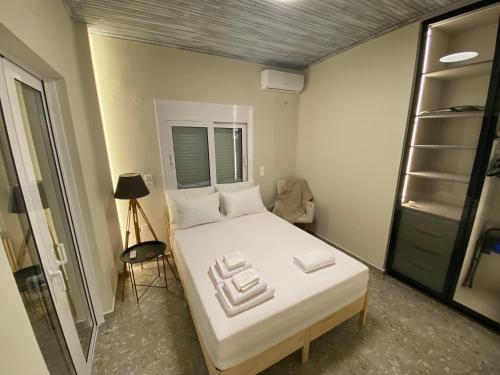 a bedroom with a large white bed and a window at Mu Caza Monemvasia in Monemvasia