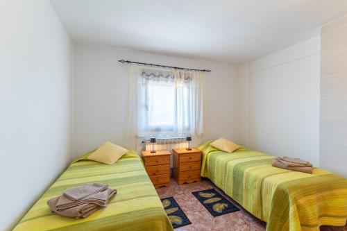 a bedroom with two beds and a window at Vivienda turística El Laurel in Valdemanco