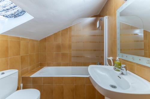 a bathroom with a tub and a sink at Vivienda turística El Laurel in Valdemanco