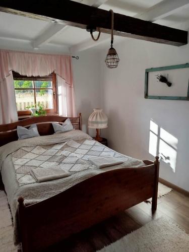 a bedroom with a bed and a window at Naprózsa Tanya in Bugac Felső Vasútállomás