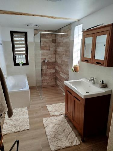 a bathroom with a tub and a sink and a shower at Naprózsa Tanya in Bugac Felső Vasútállomás