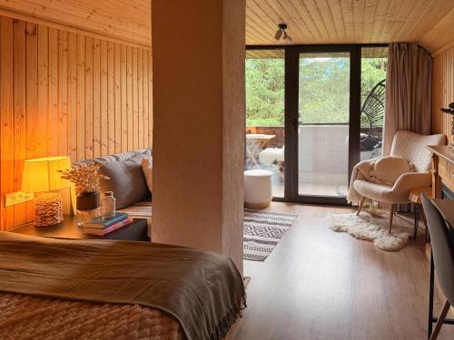 a bedroom with a bed and a living room at Cuib din Fagaras in Avrig