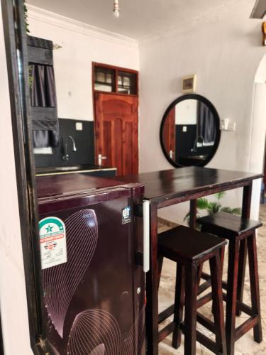 a room with a table and a mirror and a table and stool at Kilifi Tulivu in Kilifi