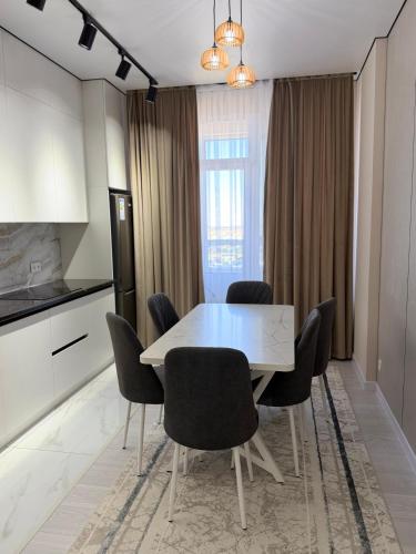 a kitchen and dining room with a table and chairs at Улы Дала in Shymkent