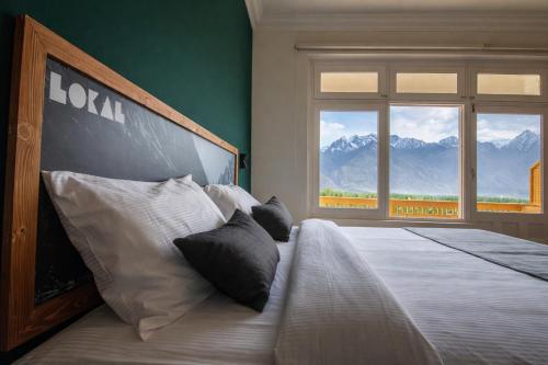 a bedroom with a large bed with a large window at Hotel Mashabrum Skardu Free Breakfast Mountain View Family Rooms & Free WiFi in Skardu