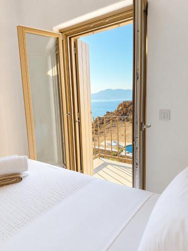 a bedroom with a bed and a view of the ocean at Lucevista Mykonos Villas in Fanari