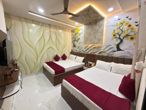 a bedroom with two beds and a wall with a tree mural at Shree Nagnath Residency in Ellora