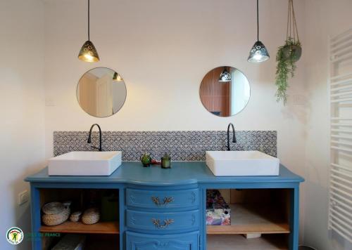 two sinks in a bathroom with two mirrors at la caquetoire in Les Églisottes-et-Chalaures