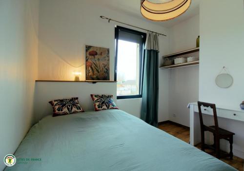 a bedroom with a bed and a desk and a window at la caquetoire in Les Églisottes-et-Chalaures