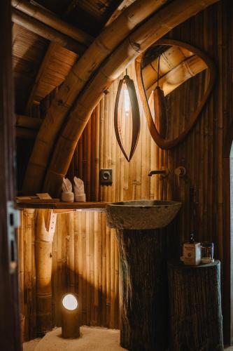 a bathroom with a sink and a wooden wall at Mandala Eco Resort Lombok in Selong Belanak