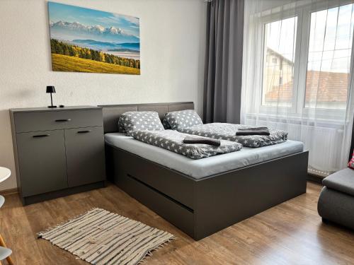 a bed in a living room with a window at Ubytovanie u Albína in Betlanovce