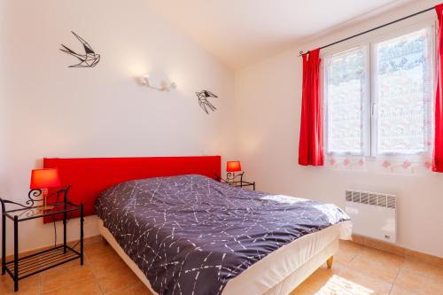 a bedroom with a bed with a red headboard at Le Figuier - La Fontinelle in Bessas