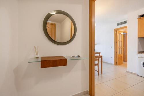 a bathroom with a mirror and a table on a wall at Torredembarra in Torredembarra