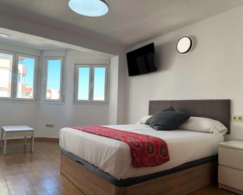 a bedroom with a bed with a television on the wall at Brisa de Torre in Torre del Mar