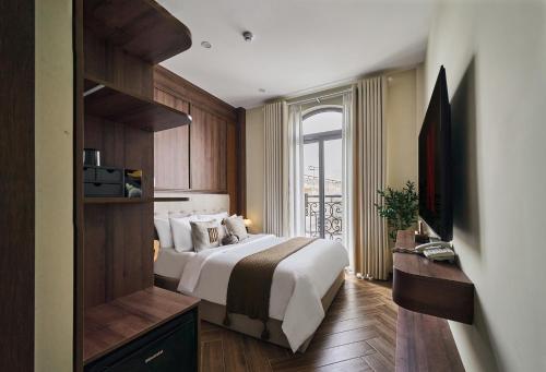 a hotel room with a bed and a window at Centoria Hotel By Urban B in Ho Chi Minh City