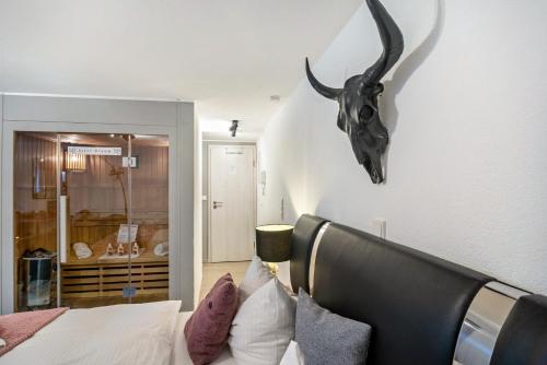 a bedroom with a bed with a antelope skull on the wall at Eifel-Dream Kalkmulde in Fleringen