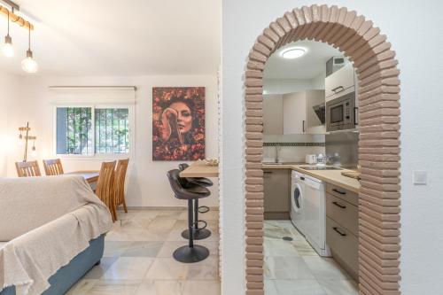 a kitchen and living room with an archway leading into a room with a bed at Sunny Calahonda Park in Sitio de Calahonda
