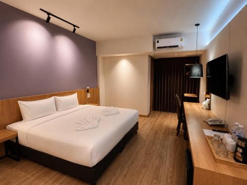 a hotel room with a large bed and a desk at The Neuf@Ratchada in Bangkok