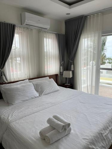 ein Schlafzimmer mit einem Bett, auf dem zwei Handtücher liegen in der Unterkunft Maykenn Beach-Cafe-Bar and Restaurant in Ocoy