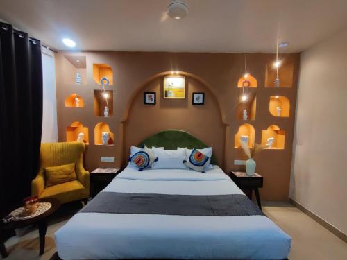 a bedroom with a large bed and a chair at Tvessa-A Boutiqe Hotel in Mandrem