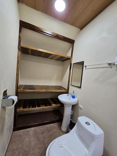 a small bathroom with a toilet and a sink at Cool Waters Jungle Villas in Uvita