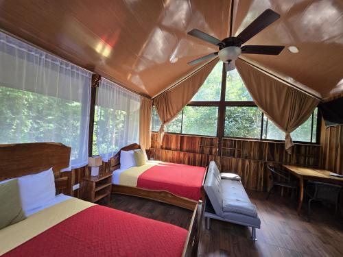 a bedroom with two beds and a ceiling fan at Cool Waters Jungle Villas in Uvita