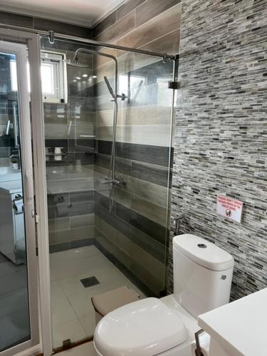 ein Badezimmer mit Toilette und Glasdusche in der Unterkunft Maykenn Beach-Cafe-Bar and Restaurant in Ocoy