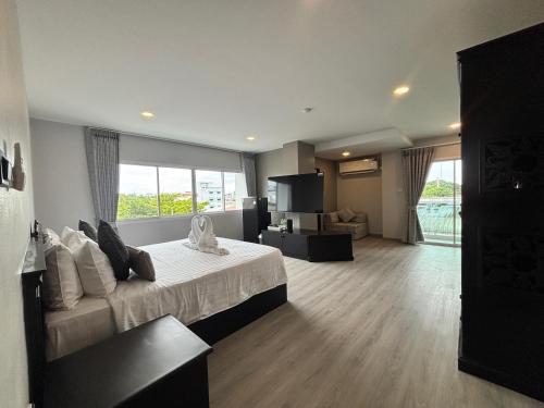 a bedroom with a bed and a living room at Hotel De Kiang Muang in Chiang Mai