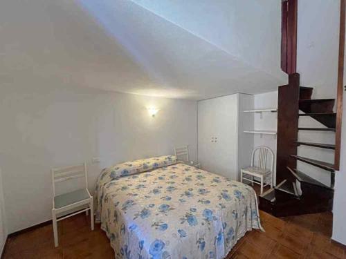 a bedroom with a bed and two chairs in it at Ammiraglio Giglio Castello in Isola del Giglio