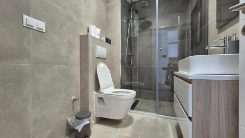 a bathroom with a toilet and a sink and a shower at MyPlace apartmani 42,56,70 in Tuzla