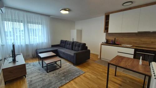 a living room with a couch and a table at MyPlace apartmani 42,56,70 in Tuzla