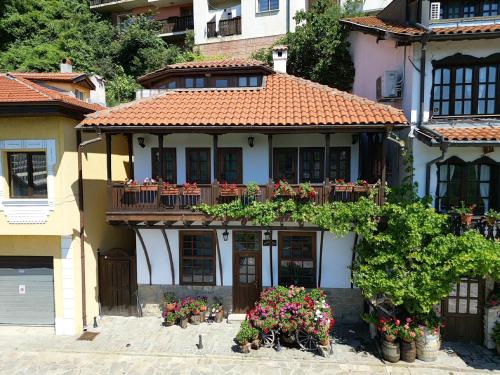ein Haus mit Blumen davor in der Unterkunft Gurko Hotel in Weliko Tarnowo