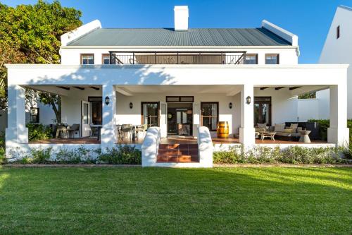 a white house with a green lawn at Winelands Golf Lodges 2 in Stellenbosch