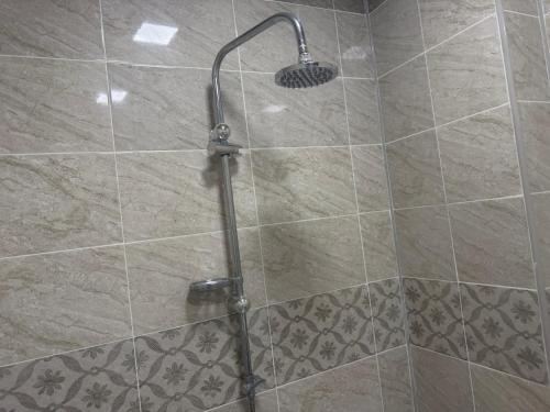 a shower with a shower head in a bathroom at Cozy house in Sheki