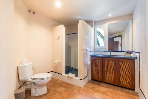 a bathroom with a toilet and a shower and a sink at Son Bou Pool and Sea in Son Bou