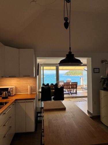 a kitchen and dining room with a view of the ocean at Seafront Apartment Strunjan in Strunjan