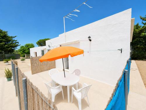 a table with an orange umbrella on the side of a building at Casa de Los Arbolitos in El Palmar