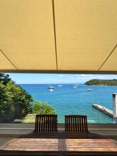 a table with two chairs and a view of the ocean at Seafront Apartment Strunjan in Strunjan