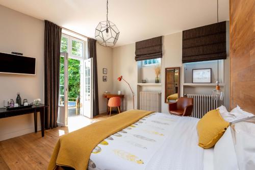 a bedroom with a large bed and a desk at B&B Clerval - Maison d'hôtes et Gîtes in Dragey