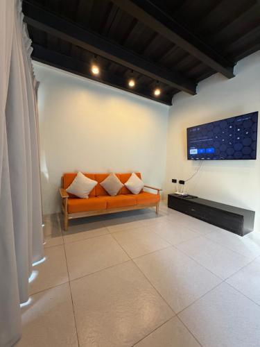 a living room with a couch and a flat screen tv at Cafe Itaewon Pool & Villa in Sampong