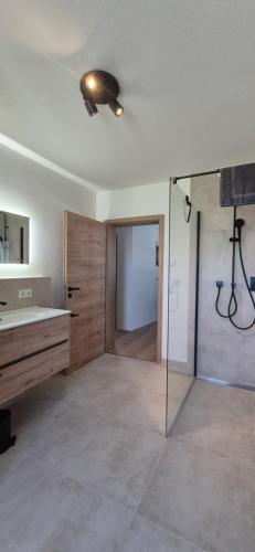 a bathroom with a shower and a sink and a glass door at Apartment Illerblick in Dettingen an der Iller