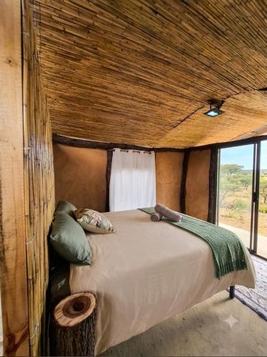a bed in a room in a safari tent at Hennies HideOut in Kachikau