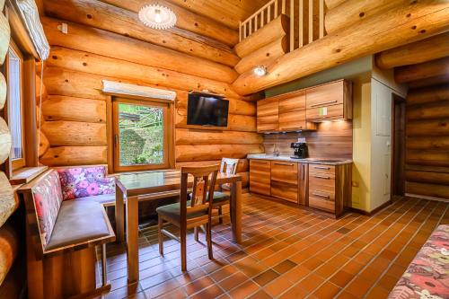 a kitchen with a table and chairs in a cabin at Holiday Home Happiness in Hočko Pohorje