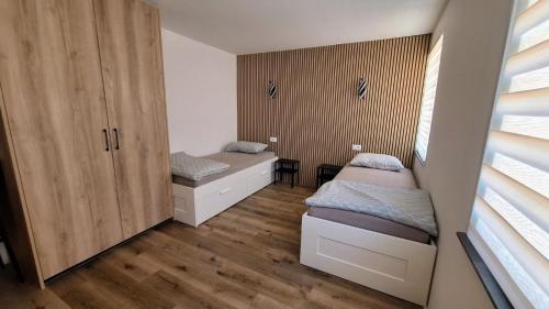 a bedroom with two beds and wooden cabinets at Sleep House in Labin
