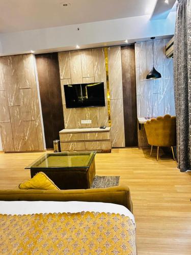 a living room with a couch and a tv at The Origin Suites opposite Hyatt Dlf my pad Lucknow in Lucknow