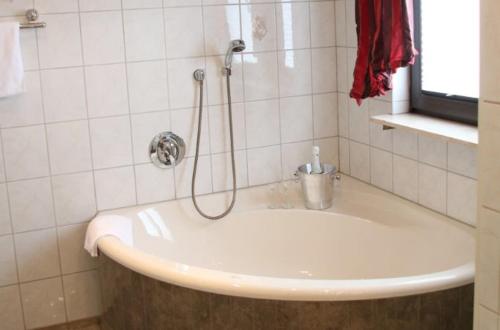 a bathroom with a bath tub with a shower at Landgasthof Hotel Bechtel in Zella