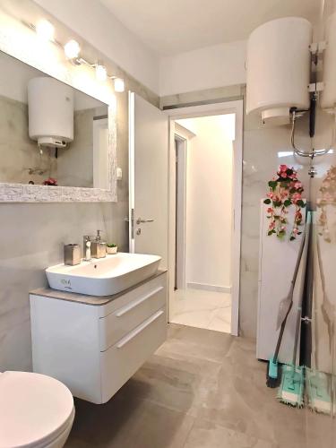a white bathroom with a sink and a toilet at Sun house in Krk